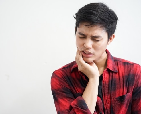 man holding jaw in pain
