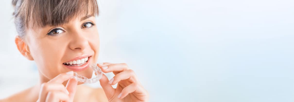 woman about to put in invisible (clear plastic) braces